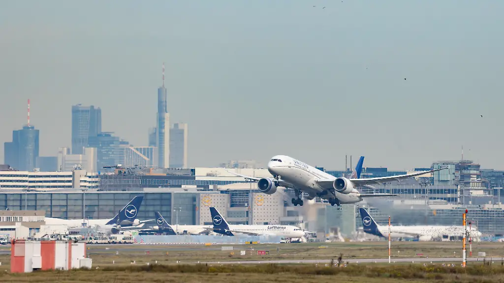 Ein-Flugzeug-der-Fluggesellschaft-United-Airlines-Boeing-787-9-Dreamliner-Kennung-N24973-startet-vom-Flughafen-Frankfurt-a-M-Im-Hintergrund-kann-man-einen-Teil-der-Skyline-der-Stadt-Frankfurt-a-M-sehen-Am-Boden-stehen-Flugzeuge-der-Lufthansa-in-der-Parkposition-Flughafen-Frankfurt-a-M-am-13-11-2025-in-Frankfurt-a-M-Deutschland