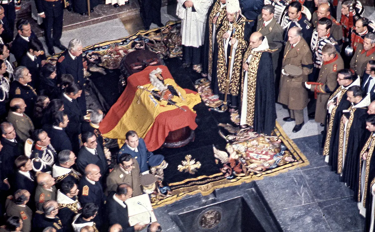 Der-Sarg-mit-den-Ueberresten-des-Diktators-Francisco-Franco-ist-bei-der-Bestattung-im-Tal-der-Gefallenen-mit-einer-franquistischen-spanischen-Flagge-bedeckt-Die-umstrittene-Umbettung-des-frueheren-spanischen-Diktators-findet-am-Donnerstag-statt-Die-sterblichen-Ueberreste-des-Gewaltherrschers-1892-1975-wuerden-an-diesem-Tag-ab-10-30-Uhr-im-Tal-der-Gefallenen-nordwestlich-von-Madrid-exhumiert-und-dann-auf-dem-Friedhof-El-Pardo-Mingorrubio-am-Nordrand-der-Stadt-beigesetzt-teilte-die-spanische-Regierung-am-Montag-mit