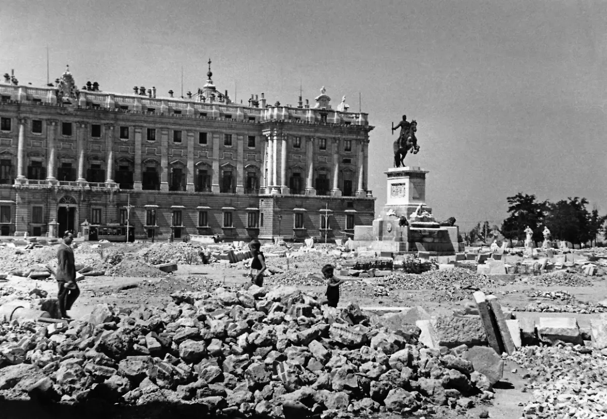 Aufnahme-der-Plaza-del-Oriente-in-Madrid-im-Fruehjahr-1939-nach-dem-Einmarsch-der-nationalspanischen-Truppen-unter-General-Francisco-Franco-Im-Hintergrund-ist-der-spanische-Koenigspalast-Palacio-Real-zu-sehen-Davor-steht-das-Reiterdenkmal-Koenig-Philipps-IV-Felipe-IV-1605-bis-1665-Das-Pflaster-des-Platzes-ist-fuer-den-Barrikadenbau-aufgerissen-Dazwischen-spielen-Kinder-Aufnahmedatum-01-01-1939-31-12