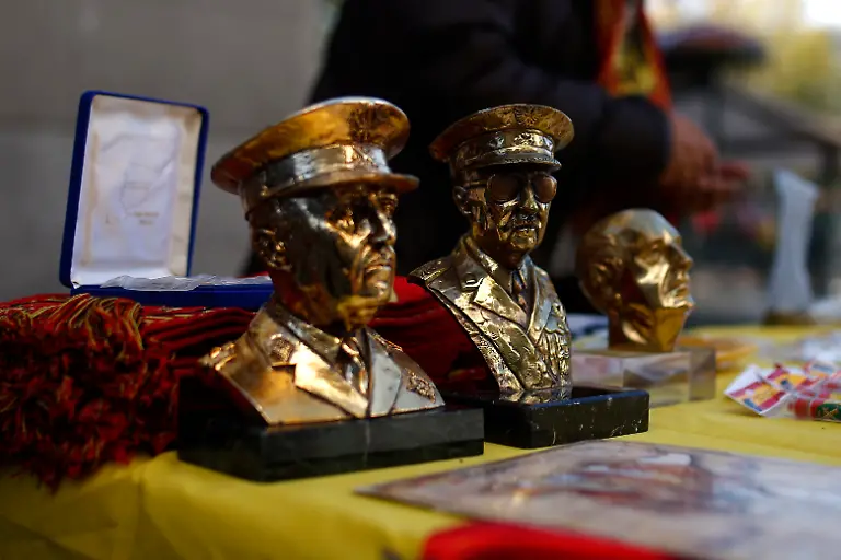 A-man-counts-coins-next-to-Franco-merchandise-during-the-38th-anniversary-of-former-Spanish-Dictator-Gen-Francisco-Franco-s-death-in-Madrid-Spain-Sunday-Nov-24-2013-Hundreds-of-people-nostalgic-for-Spain-s-fascist-past-held-a-rally-on-Sunday-to-mark-the-38th-anniversary-of-dictator-Francisco-Franco-s-death-The-peaceful-demonstration-was-held-in-Madrid-s-central-Plaza-de-Oriente-square-near-the-opera-and-Royal-Palace-in-the-city-s-old-quarter-On-Saturday-an-anti-Franco-protest-was-held-northwest-of-Madrid-at-Franco-s-mausoleum