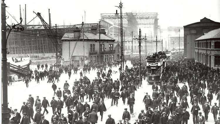 Historisches Foto mit der Queens Road im Belfaster Hafenviertel, während die Titanic (im Hintergrund auf der Helling) gebaut wurde.