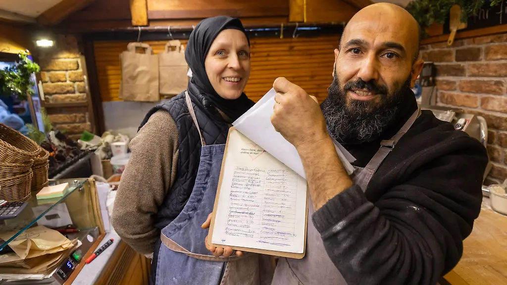 Auf-einer-Liste-notieren-Bayram-Dalkilic-und-seine-Frau-Isabell-Geldspenden-mit-denen-Kunden-kostenloses-Essen-fuer-beduerftige-Menschen-finanzieren