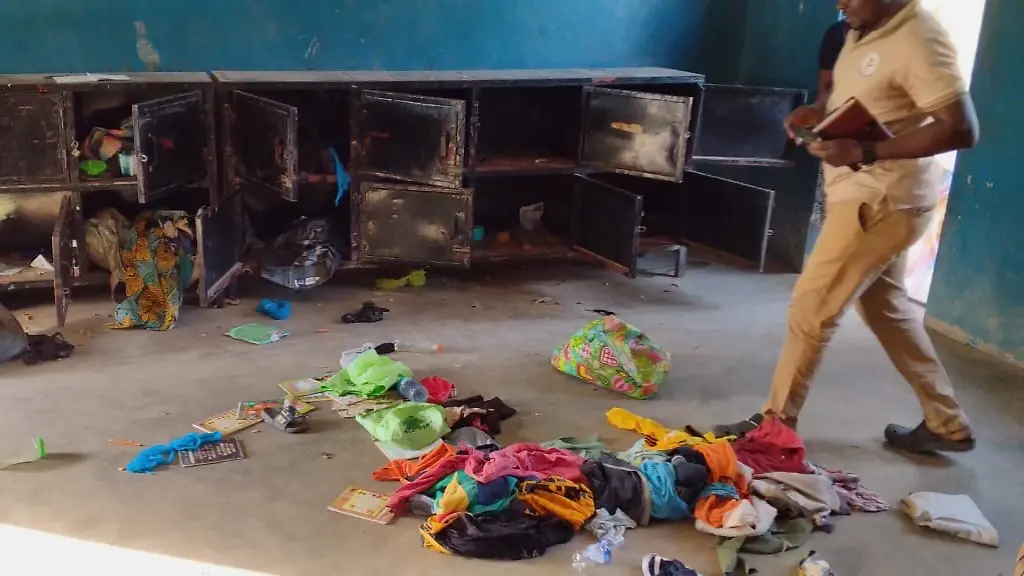 In-this-photo-released-by-Christian-Association-of-Nigeria-a-man-walk-past-belongings-at-the-St-Mary-s-Catholic-Primary-and-Secondary-School-after-gunmen-abducted-children-and-staff-in-Papiri-community-Nigeria-Friday-Nov-21-2025