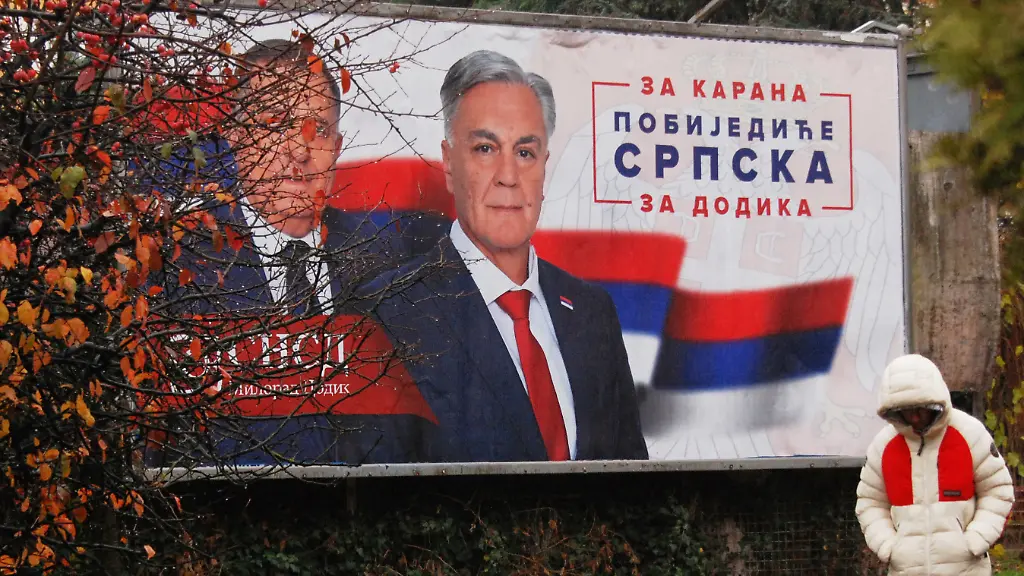 21-11-2025-Bosnien-Herzegowina-Banja-Luka-Ein-Mann-geht-an-einem-Wahlplakat-vorbei-das-den-bosnischen-Serbenfuehrer-Milorad-Dodik-und-den-Kandidaten-der-Partei-SNSD-Sinisa-Karan-zeigt-Fuer-Karan-die-Republik-Srpska-wird-gewinnen-fuer-Dodik-vor-den-vorgezogenen-Praesidentschaftswahlen-in-der-bosnischen-Stadt-Banja-Luka-240-km-nordwestlich-von-Sarajevo