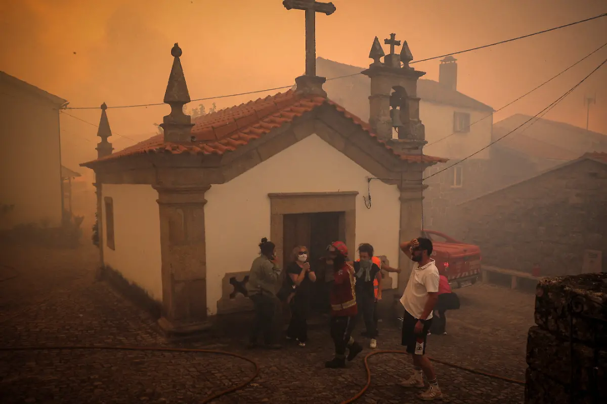 Residents-gather-outside-of-a-chapel-as-others-take-shelter-inside-while-a-wildfire-approaches-Benvende-in-Trancoso-Portugal-August-14-2025-Although-the-record-breaking-wildfires-that-ripped-across-Spain-and-Portugal-in-August-have-subsided-residents-in-rural-communities-in-Spain-s-northwestern-Galicia-region-are-still-battling-the-aftermath-What-happened-here-is-crazy-said-Cristina-Santin-a-biologist-from-northwestern-Spain-who-studies-fire-impacts-Suddenly-you-get-up-one-day-and-your-home-region-is-burning-on-a-scale-that-is-completely-unprecedented-REUTERS-Pedro-Nunes-SEARCH-IBERIA-WILDFIRES-AFTERMATH-FOR-THIS-STORY-SEARCH-WIDER-IMAGE-FOR-ALL-STORIES