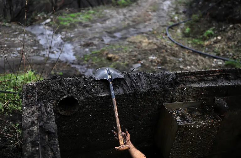 Worker-Raul-Lopez-53-uses-a-shovel-to-clean-and-unclog-a-sandtrap-or-arenero-of-the-ashes-and-mud-dragged-by-seasonal-rains-after-a-wildfire-in-August-in-the-municipality-of-Villamartin-de-Valdeorras-Galicia-Spain-November-7-2025