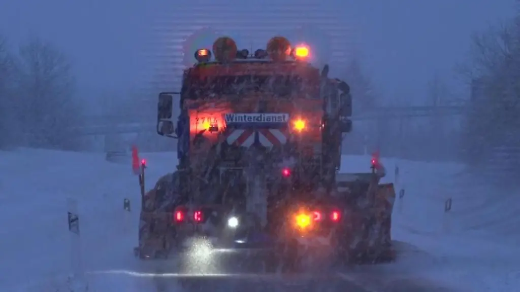 Ein-Fahrzeug-des-Winterdienstes-raeumt-eine-verschneite-Strasse