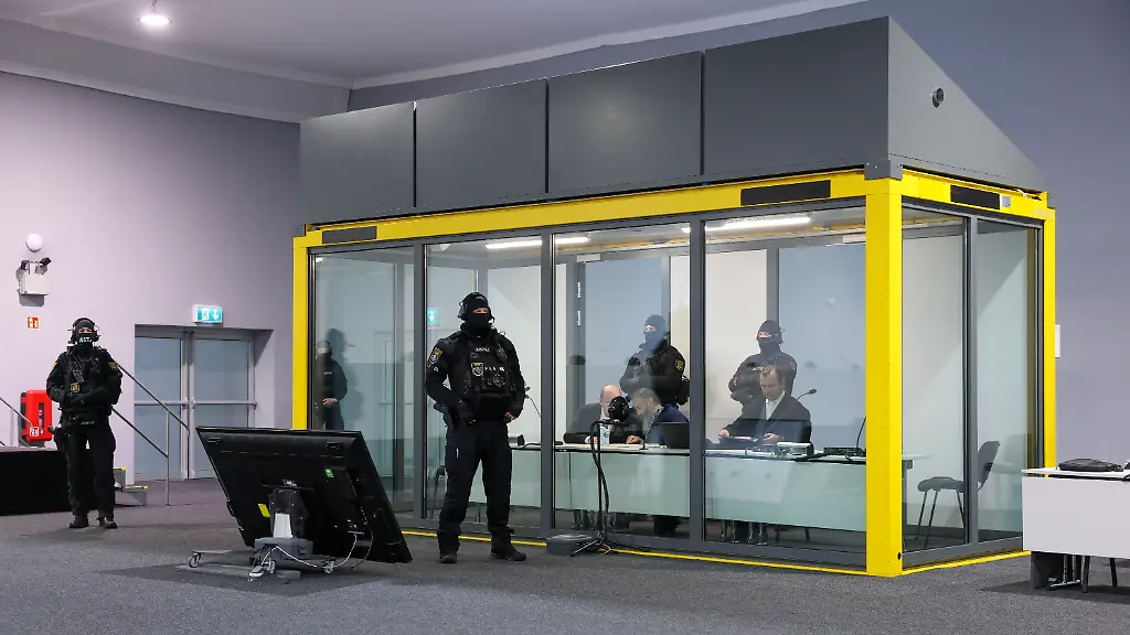 Der-Angeklagte-Taleb-al-Abdulmohsen-M-sitzt-neben-seinem-Verteidiger-Thomas-Rutkowski-r-und-einem-Dolmetscher-in-einem-kugelsicheren-Glaskasten-zur-Prozessfortfuehrung-im-temporaeren-Gerichtsgebaeude-des-Landgerichtes-Magdeburg-Die-Generalstaatsanwaltschaft-wirft-dem-Mann-aus-Saudi-Arabien-versuchten-Mord-in-338-Faellen-vor-Am-20-Dezember-2024-raste-Taleb-al-Abdulmohsen-auf-dem-Magdeburger-Weihnachtsmarkt-in-eine-Menschenmenge-Fuenf-Frauen-und-ein-Kind-starben-bei-dem-Anschlag-mehr-als-300-Menschen-wurden-verletzt