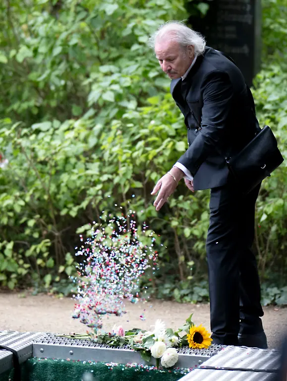 DEU-Deutschland-Germany-Berlin-26-09-2025-Leander-Haussmann-Haussmann-deutscher-Filmregisseur-und-Schauspieler-verstreut-Konfetti-am-Grab-waehrend-der-Trauerfeier-zur-Beisetzung-Beerdigung-von-Claus-Peymann-deutscher-Intendant-und-Theaterregisseur-ehemaliger-Intendant-vom-Berliner-Ensemble-und-Direktor-vom-Wiener-Burgtheater-auf-dem-Dorotheenstaedtischen-Friedhof-an-der-Chausseestrasse-im-Berliner-Bezirk-Mitte-Berlin-Deutschland-Der-Theaterregisseur-galt-als-Theaterpapst-der-deutschen-und-oesterreichischen-Theaterszene-und-war-am-16-07-im-Alter-von-88-Jahren-gestorben-en-Leander-Haussmann-Haussmann-German-film-director-and-actor-scatters-confetti-at-the-grave-during-the-funeral-service-for-Claus-Peymann-German-artistic-director-and-theater-director-former-artistic-director-of-the-Berliner-Ensemble-and-director-of-the-Vienna-Burgtheater-at-the-Dorotheenstadt-Cemetery-on-Chausseestrasse-in-the-Mitte-district-of-Berlin-Germany-The-theater-director-was-considered-the-theater-pope-of-the-German-and-Austrian-theater-scene-and-died-on-July-16-at-the-age-of-88