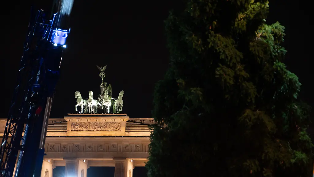 Zwischen-dem-Arm-eines-Krans-und-einer-Fichte-ist-die-Quadriga-auf-dem-Brandenburger-Tor-zu-sehen