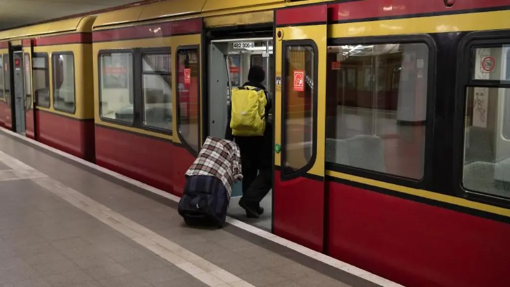 Ein-Mann-mit-Mund-und-Nasenschutz-steigt-in-eine-Bahn