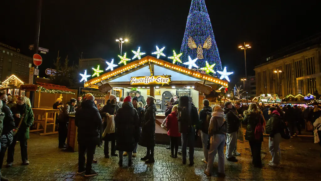 DORTMUND-GERMANY-NOVEMBER-24-People-attend-the-Dortmund-Christmas-market-in-which-the-traditional-45-meter-high-Christmas-tree-the-world-s-largest-is-illuminated-for-the-first-time-this-year-on-November-24-2025-in-Dortmund-Germany