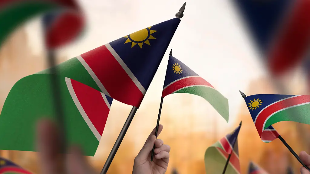 Namibia-flags-in-their-hands-on-a-blurred-urban-background-The-photo-illustration-was-created-without-the-use-of-artificial-intelligence-only-using-Photoshop