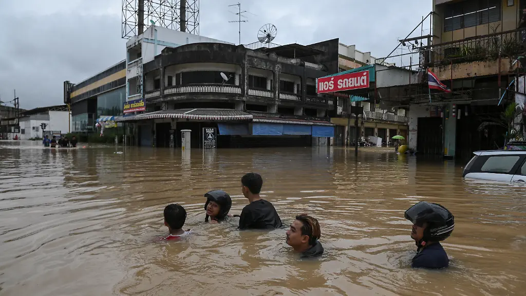 Local-residents-wade-through-a-flooded-area-in-Hat-Yai-district-affected-by-heavy-rainfall-which-has-impacted-several-provinces-in-southern-Thailand-and-has-killed-several-people-in-Songkhla-province-Thailand-November-25-2025