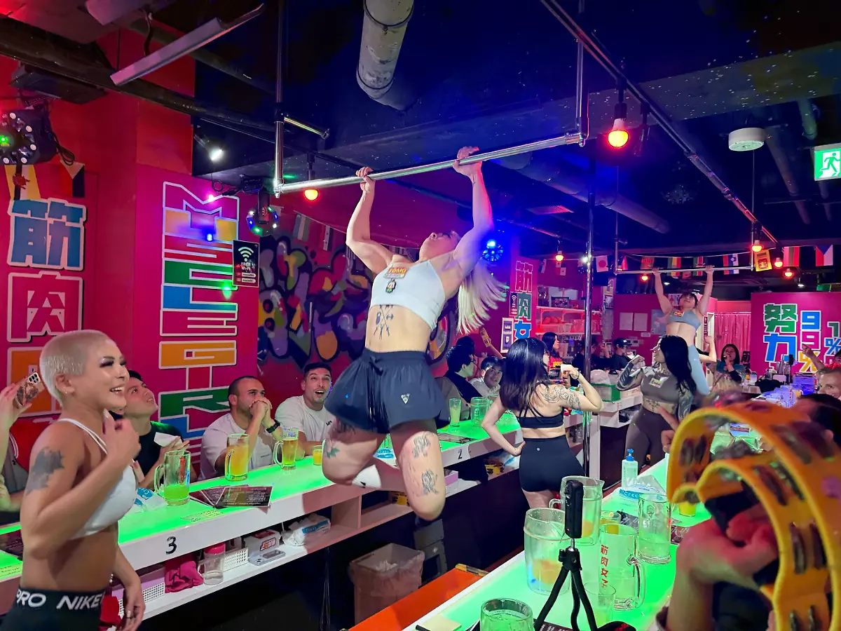 ARCHIV-19-11-2025-Japan-Tokio-Gaeste-vergnuegen-sich-in-der-Bar-Muscle-Girls-in-Tokio