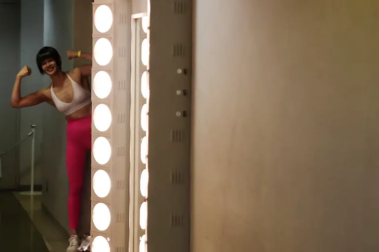 Misaki-Chiba-31-a-staffer-at-Muscle-Girls-a-fitness-themed-bar-in-Tokyo-poses-for-her-colleagues-backstage-during-a-regional-competition-of-Muscle-Gate-a-bodybuilding-tournament-in-Saitama-Japan-October-11-2025-REUTERS-Kim-Kyung-Hoon-SEARCH-KYUNG-HOON-MUSCLE-GIRLS-FOR-THIS-STORY-SEARCH-WIDER-IMAGE-FOR-ALL-STORIES