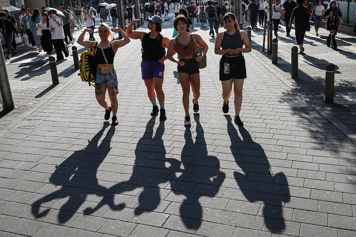 Tomomi-Matsumoto-35-and-Hitomi-Hariage-38-staffers-at-Muscle-Girls-a-fitness-themed-bar-flex-their-muscles-while-walking-with-Eri-Maeda-28-and-Mahoka-Kishizawa-25-at-a-shopping-district-near-work-in-Tokyo-Japan-September-17-2025-Female-bodybuilding-has-gained-popularity-in-Japan-in-recent-years-with-competitions-held-in-many-cities-But-outside-that-circle-the-old-conventions-rule-Harigae-said-REUTERS-Kim-Kyung-Hoon-SEARCH-KYUNG-HOON-MUSCLE-GIRLS-FOR-THIS-STORY-SEARCH-WIDER-IMAGE-FOR-ALL-STORIES