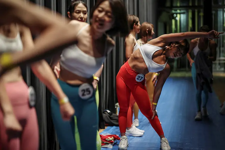 Eri-Maeda-28-a-staffer-at-Muscle-Girls-a-fitness-themed-bar-in-Tokyo-stretches-before-going-on-stage-to-participate-in-the-regional-competition-of-Muscle-Gate-a-bodybuilding-tournament-in-Saitama-Japan-October-11-2025-REUTERS-Kim-Kyung-Hoon-SEARCH-KYUNG-HOON-MUSCLE-GIRLS-FOR-THIS-STORY-SEARCH-WIDER-IMAGE-FOR-ALL-STORIES