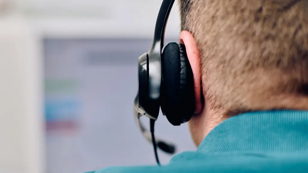 A-detailed-close-up-captures-a-focused-customer-support-representative-wearing-a-headset-while-providing-assistance-in-a-call-center-setting