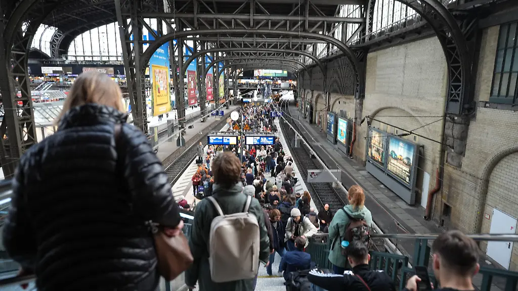 Fahrgaeste-warten-am-Bahnsteig-auf-ihren-Zug-im-Hauptbahnhof-Hamburg-Wegen-eines-Kabelschadens-ist-der-Zugverkehr-am-Hamburger-Hauptbahnhof-seit-heute-Nachmittag-stark-beeintraechtigt-Das-teilte-die-Deutsche-Bahn-mit