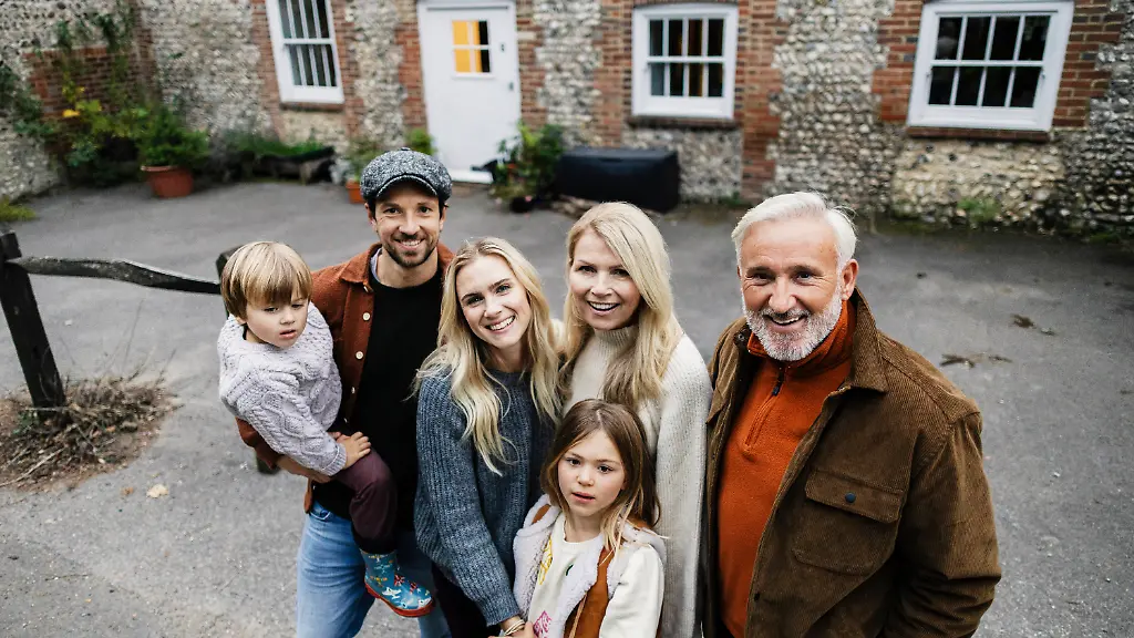 Smiling-family-group-bonding-outdoors-in-front-of-house-model-released-Symbolfoto-ASGF07292