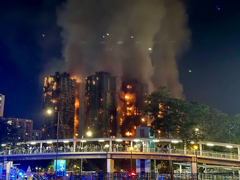 HONG-KONG-CHINA-NOVEMBER-26-Thick-smoke-and-flames-rise-as-fire-engulfs-high-rise-residential-buildings-at-the-Wang-Fuk-Court-complex-on-November-26-2025-in-Hong-Kong-China-At-least-13-people-are-dead-and-dozens-of-others-injured-as-a-major-fire-engulfed-a-residential-apartment-complex-in-Hong-Kong-s-Tai-Po-district-on-November-26