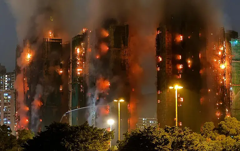 Thick-smoke-and-flames-rise-as-a-major-fire-engulfs-several-apartment-blocks-at-the-Wang-Fuk-Court-residential-estate-in-Hong-Kong-s-Tai-Po-district-on-November-26-2025-At-least-four-people-were-killed-when-a-fire-engulfed-several-high-rise-blocks-in-a-Hong-Kong-residential-estate-on-November-26-the-government-said-with-media-reporting-that-some-residents-were-trapped-inside