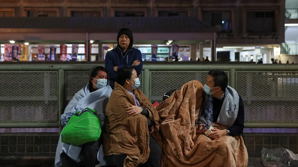 Evacuees-wrapped-in-blankets-rest-on-a-nearby-platform-after-a-major-fire-at-Wang-Fuk-Court-housing-estate-in-Tai-Po-Hong-Kong-China-November-26-2025