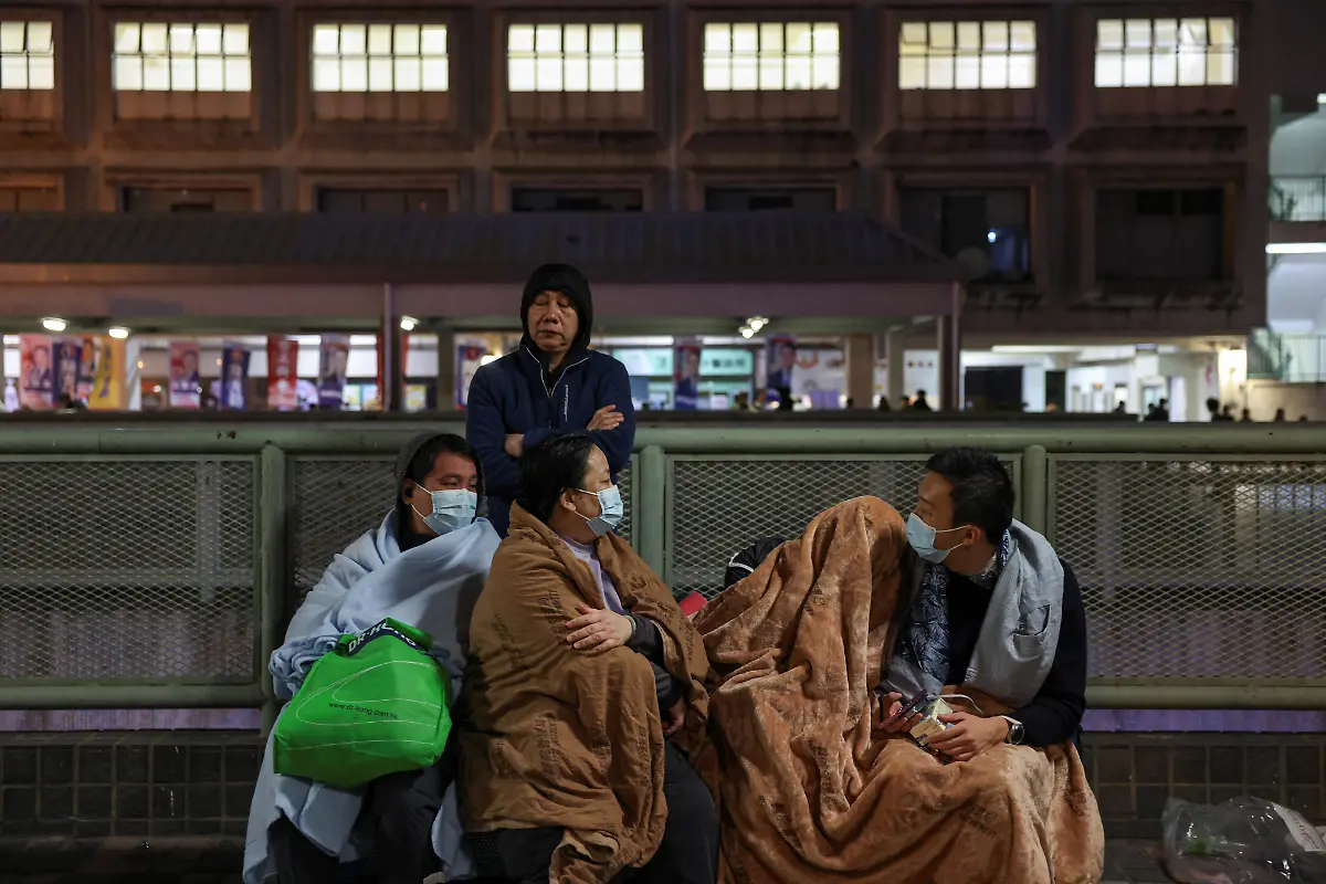Evacuees-wrapped-in-blankets-rest-on-a-nearby-platform-after-a-major-fire-at-Wang-Fuk-Court-housing-estate-in-Tai-Po-Hong-Kong-China-November-26-2025