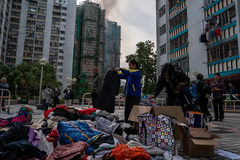 November-27-2025-Hong-Kong-Hong-Kong-People-getting-clothes-from-a-pile-of-clothes-as-a-major-fire-engulfs-several-residential-buildings-at-Wang-Fuk-Court-on-November-27-2025-in-Hong-Kong-Serval-residential-building-in-Wang-Fuk-Court-located-in-Tai-Po-District-caught-fire-today-the-Hong-Kong-Fire-Department-has-issued-the-No-5-fire-alarm-the-fire-at-local-time-0500-44-Dead