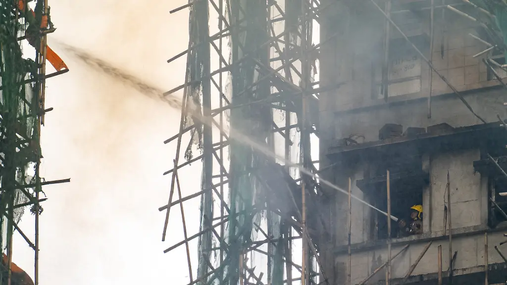 Ein-Feuerwehrmann-loescht-ein-Feuer-das-im-Wang-Fuk-Court-einer-Wohnsiedlung-im-Stadtteil-Tai-Po-in-den-New-Territories-von-Hongkong-ausbrach