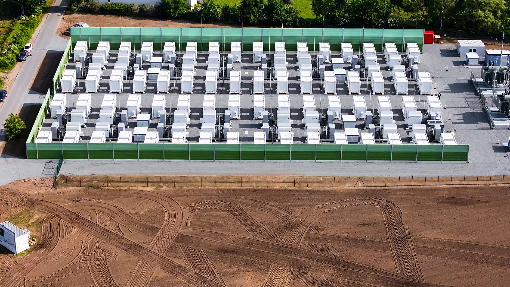 Blick-auf-den-Batteriegrossspeicher-Aufnahme-mit-einer-Drohne-Hier-werden-Produktionsueberschuesse-an-Wind-und-PV-Strom-netzentlastend-gespeichert-und-koennen-waehrend-Spitzenlastzeiten-in-das-Netz-gespeist-werden