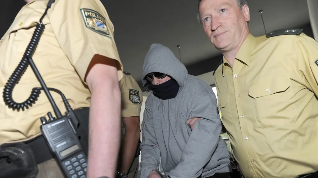 Der-angeklagte-Amoklaeufer-Georg-R-trifft-vermummt-und-in-Handschellen-unter-polizeilicher-Bewachung-am-Donnerstag-29-04-2010-im-Landgericht-Ansbach-Mittelfranken-ein-Im-Prozess-gegen-den-19-Jaehrigen-ist-fuer-Donnerstag-das-Urteil-angekuendigt-Im-September-2009-war-der-damalige-Abiturient-bewaffnet-in-das-Gymnasium-Carolinum-ins-Ansbach-gestuermt-und-hatte-Brandsaetze-in-zwei-Klassenzimmer-geworfen-Vor-der-Tuere-schlug-er-mit-einem-Beil-auf-die-fluechtenden-Schueler-ein-Bei-der-brutalen-Tat-verletzte-er-13-Schueler-und-zwei-Lehrerinnen-Die-Staatsanwaltschaft-beschuldigt-ihn-unter-anderem-des-versuchten-Mordes-in-47-Faellen