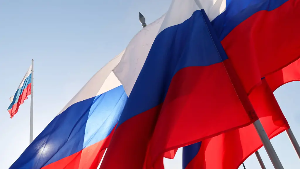 RUSSIA-AMUR-REGION-FEBRUARY-23-2025-Russian-national-flags-wave-during-an-ice-racing-event-as-part-of-the-7th-Russian-Chinese-Winter-Sports-Festival-on-the-frozen-Amur-River