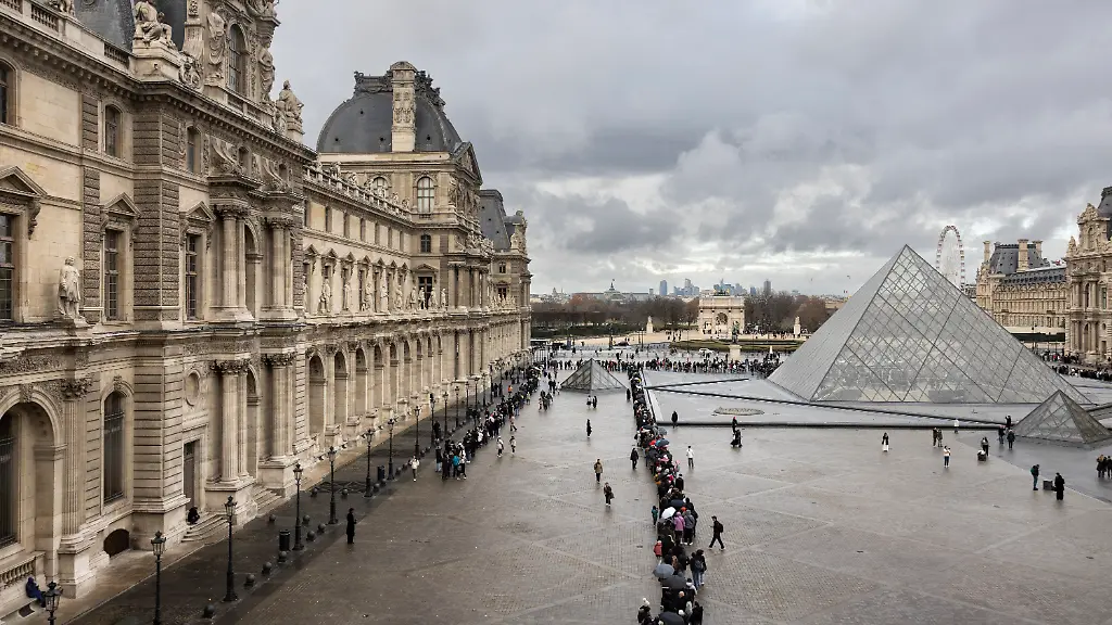 FILES-This-photograph-shows-visitors-seen-from-the-Sully-wing-queuing-in-the-Cour-Napoleon-by-the-pyramid-designed-by-Chinese-US-architect-Ieoh-Ming-Pei-to-enter-the-Louvre-Museum-in-Paris-on-November-19-2025-The-Louvre-decided-on-November-27-2025-to-increase-the-entrance-ticket-price-for-non-European-visitors-by-45-starting-in-2026-a-measure-promoted-by-the-government-and-criticized-by-unions-the-museum-and-employee-organizations-told-AFP