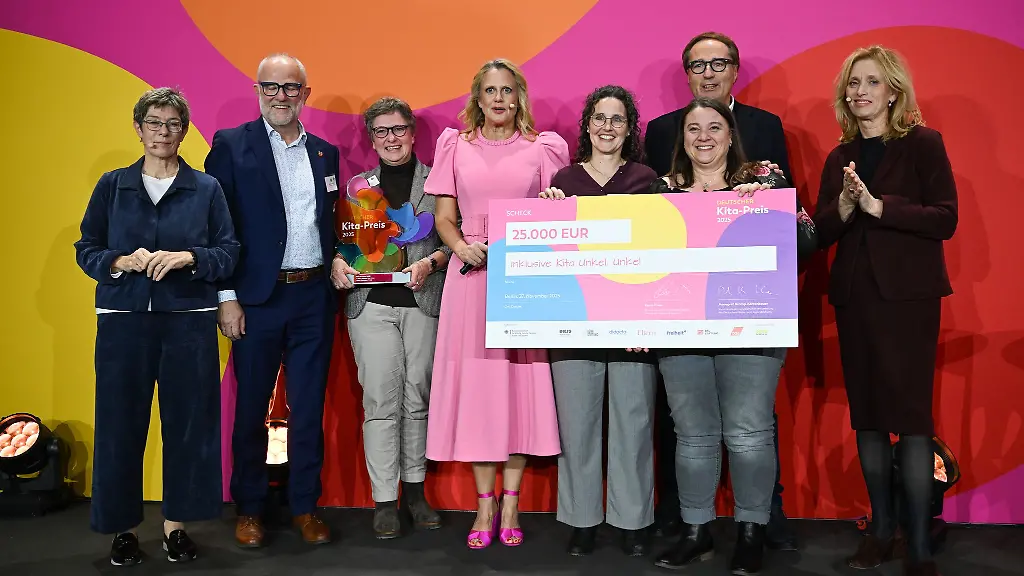 Vertreter-der-Kita-aus-Unkel-nehmen-die-Auszeichnung-von-Moderatorin-Barbara-Schoeneberger-M-Bundesfamilienministerin-Karin-Prien-CDU-entgegen