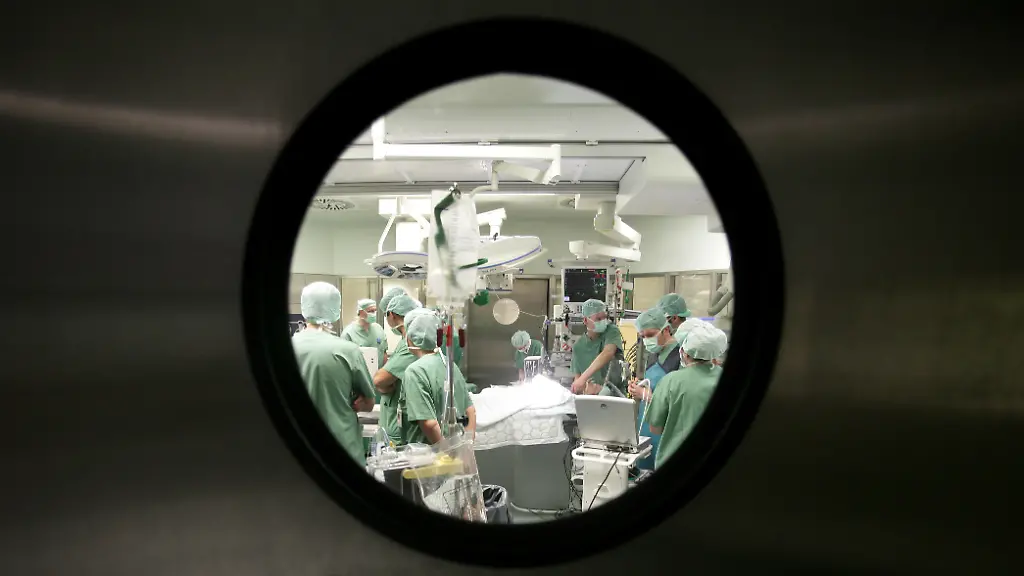 26-05-2008-Berlin-Deutschland-Aerzte-waehrend-einer-Herzoperation-im-Deutschen-Herzzentrum-im-Virchow-Klinikum-Aerzte-Arbeit-arbeiten-Berlin-Beruf-Chirurgie-chirurgische-Kleidung-deutsch-Deutsches-Herzzentrum-Deutsches-Herzzentrum-Berlin-Deutschland-DHZB-Durchsicht-Eingriff-Europa-Fenster-Gesundheitssystem-Gesundheitswesen-Guckloch-Haube-Herz-Herzoperation-Herzspezialisten-innen-Innenaufnahme-Klinik-Krankenhaus-Medizin-Mediziner-medizinisch-Menschen-Mundschutz-OP-OP-6-OP-Saal-OP-Team-Operation-Operationssaal-operieren-Schild-steril-Team-Technologie-Tuer-Virchow-Klinikum-QF-Aerzte-Tuer-0PA080526D012CARO