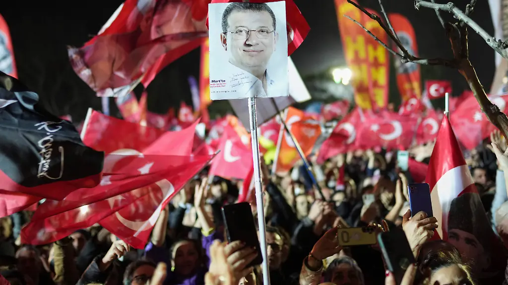 Demonstranten-schwenken-Fahnen-und-halten-Bilder-des-festgenommenen-Istanbuler-Buergermeisters-Imamoglu-hoch-waehrend-eines-Protests-gegen-die-nationale-Regierung-Symbolbild-zu-dpa-Ermittler-fordern-bis-zu-2