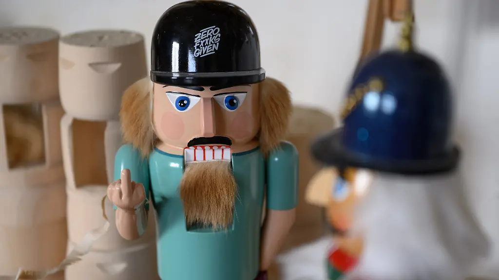 Der-echt-erzgebirgische-Nussknacker-l-aus-der-Werkstatt-von-Markus-Fuechtner-zeigt-der-Billigkopie-aus-China-r-den-Stinkefinger-15-Stueck-der-rebellischen-Holzfigur-hat-der-Holzspielzeugmacher-hergestellt-nachdem-im-Nachbarort-eine-Nussknacker-Billigkopie-aus-China-angeboten-wurde-Ein-Exemplar-steht-nach-wie-vor-in-seiner-Werkstatt-neben-der-Drechselbank