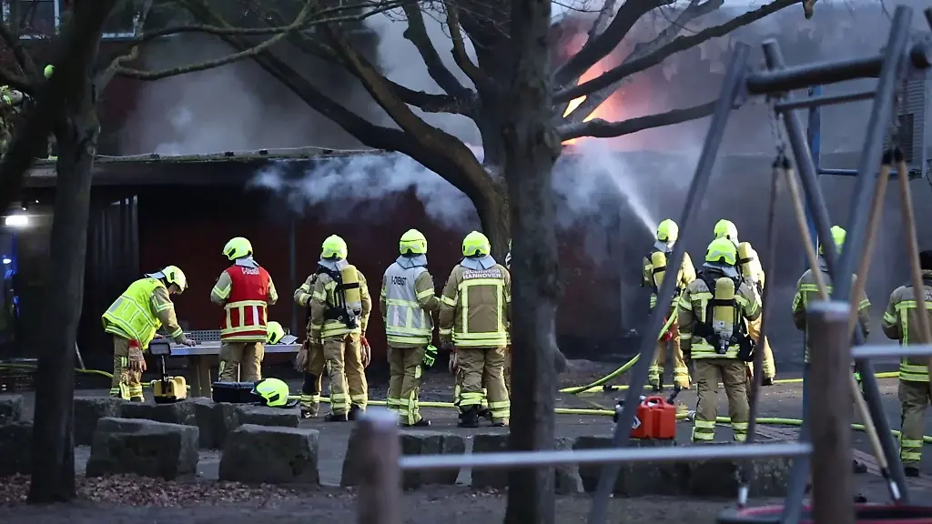 Bis-in-die-Nacht-loeschen-Feuerwehrleute-die-Flammen-in-der-Grundschule