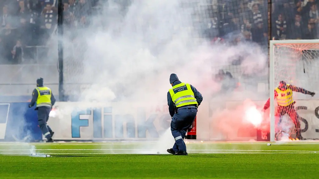 251129-Ordningsvakter-slaecker-eld-pa-graesmattan-under-match-tva-i-kvalet-till-Allsvenskan-mellan-IFK-Norrkoeping-och-Oergryte-den-29-november-2025-i-Norrkoeping