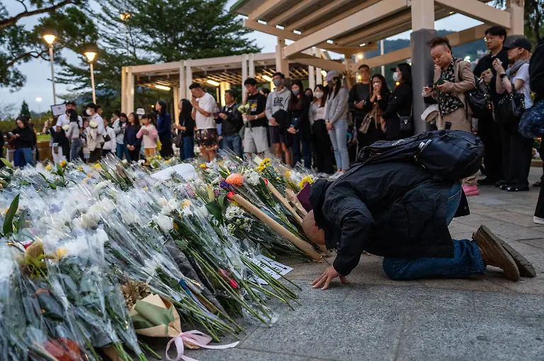 November-30-2025-Hong-Kong-Hong-Kong-A-man-kneeling-on-the-ground-at-a-makeshift-memorial-near-Wang-Fuk-Court-housing-complex-in-Tai-Po-following-a-deadly-fire-on-November-30-2025-in-Hong-Kong