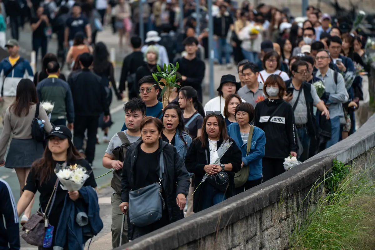 Mourners-lining-up-to-lay-flowers-at-a-makeshift-memorial-near-Wang-Fuk-Court-housing-complex-in-Tai-Po-following-a-deadly-fire-on-November-30-2025-in-Hong-Kong