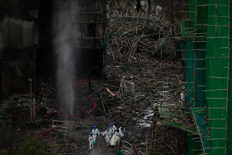 Emergency-crew-remove-what-appears-to-be-a-body-bag-from-the-site-of-a-deadly-Wednesday-fire-at-Wang-Fuk-Court-a-residential-estate-in-the-Tai-Po-district-of-Hong-Kong-s-New-Territories-on-Sunday-Nov-30-2025