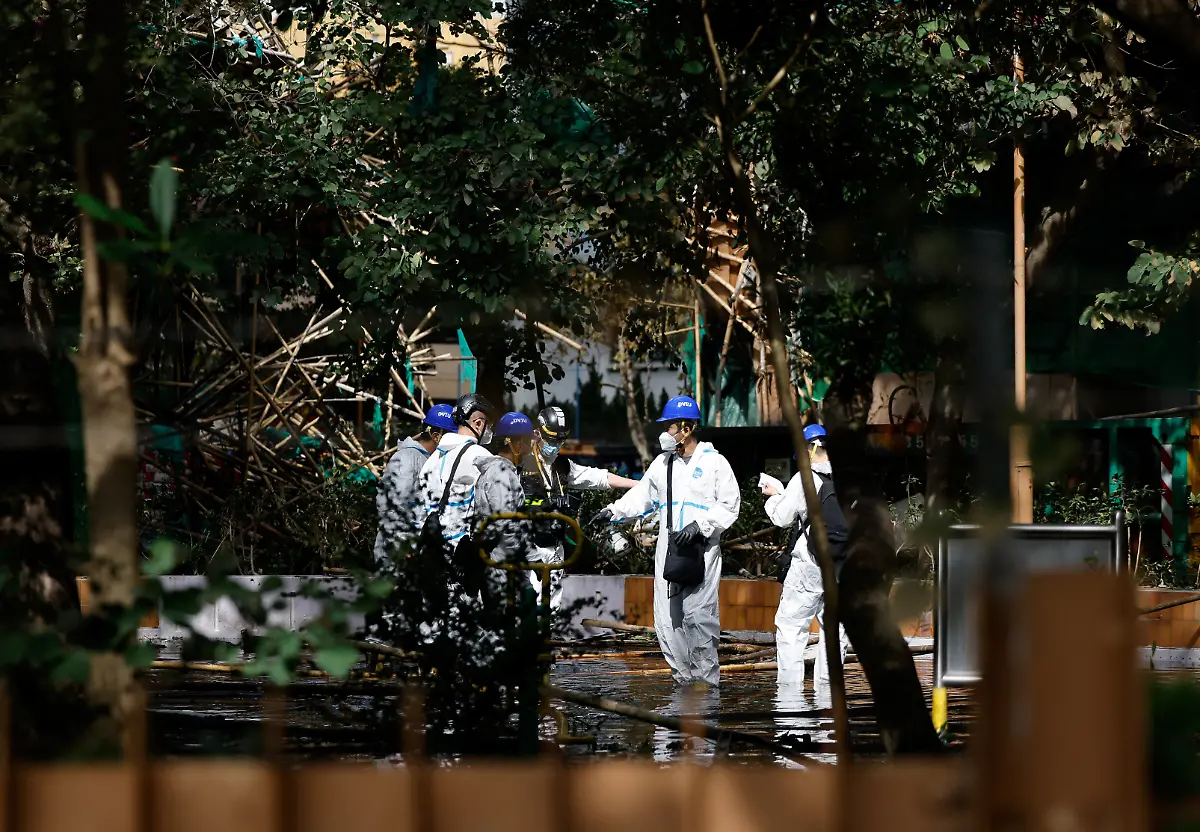 Rescue-workers-wearing-personal-protective-equipment-stand-next-to-the-buildings-of-the-Wang-Fuk-Court-housing-complex-after-the-deadly-fire-in-Tai-Po-Hong-Kong-China-November-29-2025