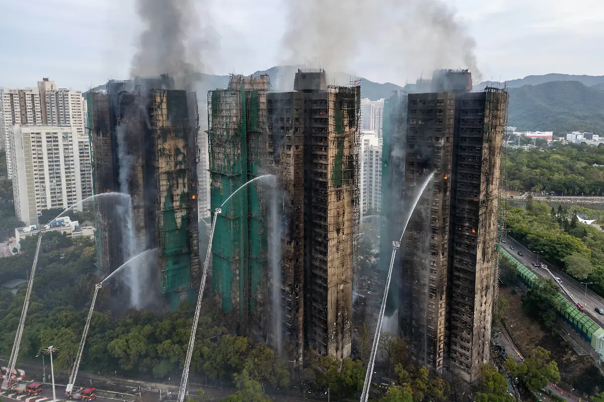 Rauch-steigt-auf-waehrend-Feuerwehrleute-die-letzten-Flammen-in-den-Gebaeuden-im-Wang-Fuk-Court-einer-Wohnsiedlung-im-Stadtteil-Tai-Po-in-den-New-Territories-von-Hongkong-ausbrach