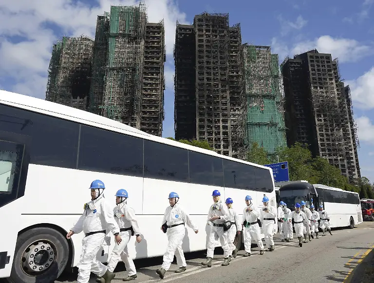 Police-officers-in-protective-gear-enter-the-high-rise-apartment-building-where-the-fire-broke-out-to-search-for-missing-people-in-Tai-Po-District-northern-Hong-Kong-on-November-29-2025-The-fire-killed-at-least-128-people-and-left-150-others-unreachable-as-of-the-30th-The-fire-broke-out-around-3-00-PM-on-the-26th-in-a-section-of-eight-public-apartment-buildings-over-30-stories-high-burning-a-total-of-seven-buildings-The-apartment-complex-was-completed-in-1983-and-has-been-undergoing-extensive-renovations-since-July-of-last-year