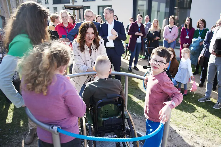 Ex-Eiskunstlaeuferin-Katarina-Witt-M-gibt-Kindern-bei-der-feierlichen-Eroeffnung-des-Sozialpaediatrischen-Zentrums-Potsdam-und-seines-Spielplatzes-Anschwung-bei-einem-Karussell-Nach-einer-dreijaehrigen-Planungs-und-Umsetzungsphase-koennen-an-diesem-neuen-Standort-Kinder-und-Jugendliche-mit-Behinderungen-behandelt-werden