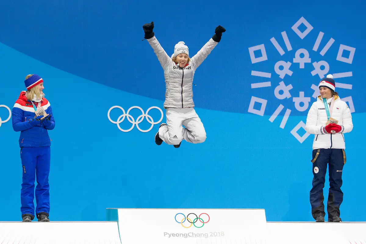 WomenOs-7-5m-sprint-biathlon-gold-medalist-Laura-Dahlmeier-of-Germany-C-leaps-on-the-podium-during-a-medal-ceremony-for-the-Pyeongchang-2018-Winter-Olympics-at-the-Olympic-Medal-Plaza-in-Daegwalnyeong-South-Korea-on-February-11-2018-Looking-on-are-silver-medalist-Marte-Olsbu-of-Norway-L-and-bronze-medalist-Veronica-Vitkova-of-the-Czech-Republic