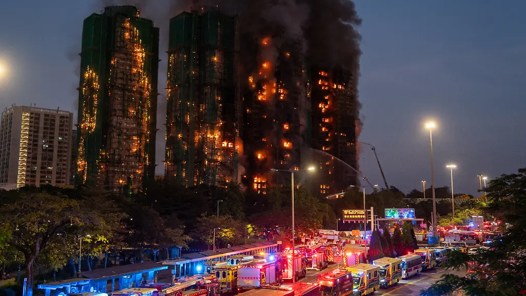 November-26-2025-Hong-Kong-Hong-Kong-Emergency-vehicles-parked-in-a-road-where-Smoke-and-flames-rise-as-a-major-fire-engulfs-several-residential-buildings-at-Wang-Fuk-Court-on-November-26-2025-in-Hong-Kong-Serval-residential-building-in-Wang-Fuk-Court-located-in-Tai-Po-District-caught-fire-today-the-Hong-Kong-Fire-Department-has-issued-the-No-5-fire-alarm-the-fire-at-local-time-1800-has-claimed-the-life-of-one-firefighter-and-three-other-people